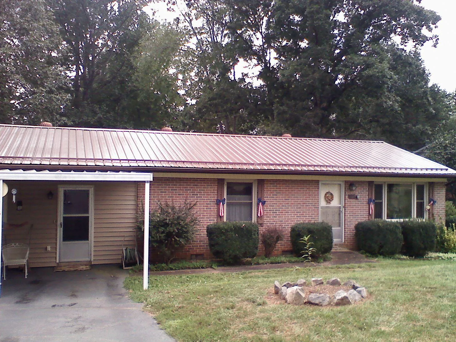 Bronze metal roof and carport on a brick ranch home — Roof Repair work by our crew in Rogerson